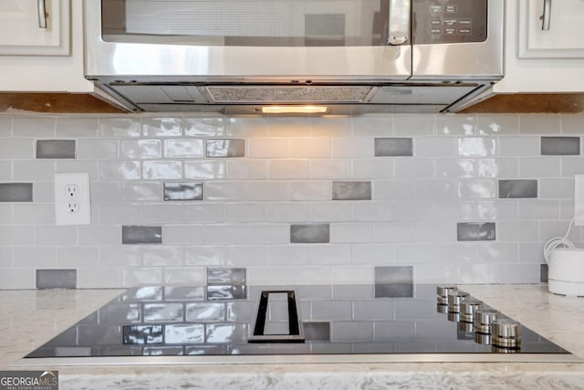 2535 Winthrope Way, Lawrenceville, GA 30044 - kitchen with stainless steel microwave, decorative backsplash, light stone countertops, and white cabinets
