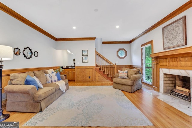 2535 Winthrope Way, Lawrenceville, GA 30044 - living area featuring ornamental molding, light wood finished floors, stairs, a wainscoted wall, and a fireplace