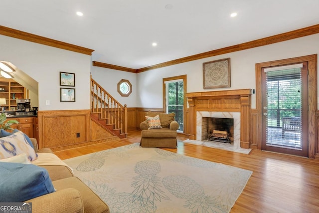 2535 Winthrope Way, Lawrenceville, GA 30044 - living room with crown molding, light wood-style floors, wainscoting, stairway, and plenty of natural light