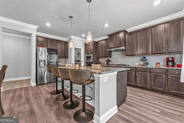 51 Waterfowl Ct, Jefferson, GA 30549 - kitchen featuring stainless steel fridge, light stone countertops, dark brown cabinets, ornamental molding, and light wood-style floors
