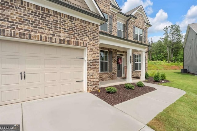 51 Waterfowl Ct, Jefferson, GA 30549 - doorway to property featuring brick siding, covered porch, concrete driveway, and a yard