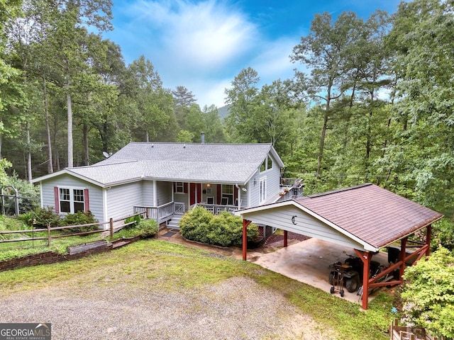 311 Lonesome Pine Trl, Blairsville, GA 30512 - view of front of house featuring covered porch, driveway, a carport, roof with shingles, and a forest view