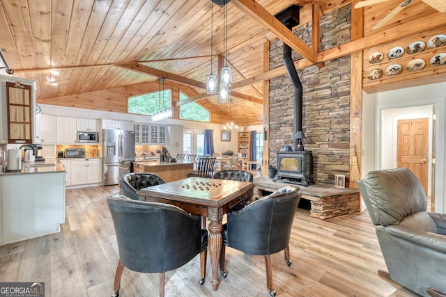311 Lonesome Pine Trl, Blairsville, GA 30512 - dining area with a wood stove, light wood-type flooring, a chandelier, wood ceiling with exposed beams, and high vaulted ceiling