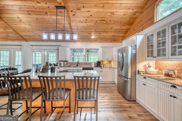 311 Lonesome Pine Trl, Blairsville, GA 30512 - kitchen with stainless steel fridge, wood ceiling, lofted ceiling, white cabinetry, and light wood-type flooring