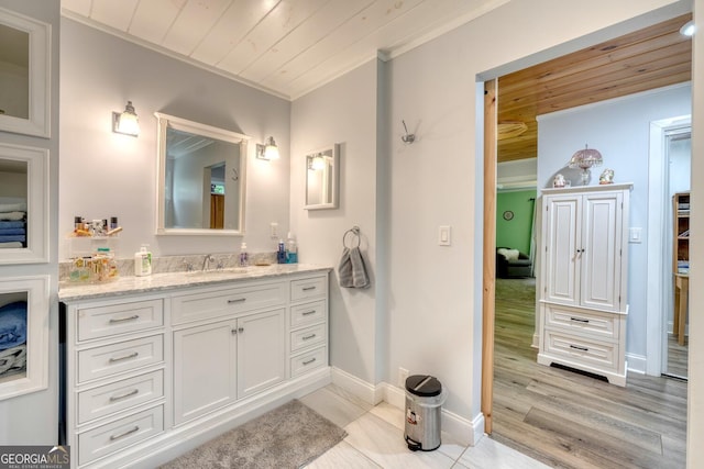 311 Lonesome Pine Trl, Blairsville, GA 30512 - bathroom with ornamental molding, wooden ceiling, vanity, wood finished floors, and baseboards