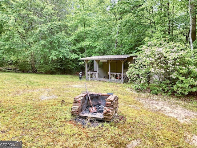 311 Lonesome Pine Trl, Blairsville, GA 30512 - view of grassy yard with an outdoor fire pit, a view of trees, and a porch