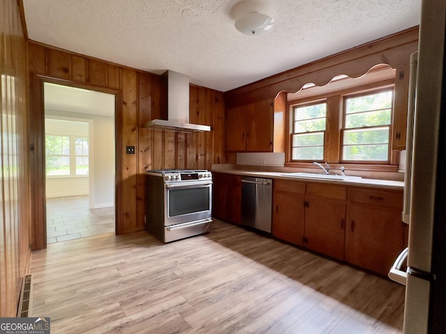 4 Walton Way NW, Rome, GA 30165 - kitchen featuring stainless steel appliances, wall chimney range hood, a sink, wood walls, and light countertops