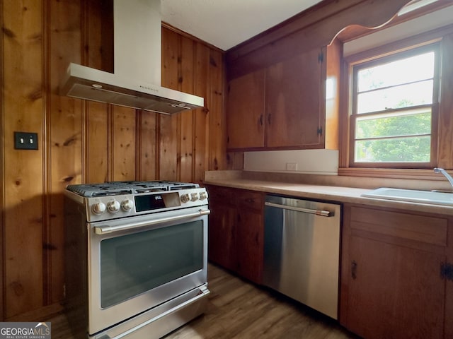 4 Walton Way NW, Rome, GA 30165 - kitchen featuring appliances with stainless steel finishes, wall chimney range hood, light countertops, light wood-style flooring, and wood walls