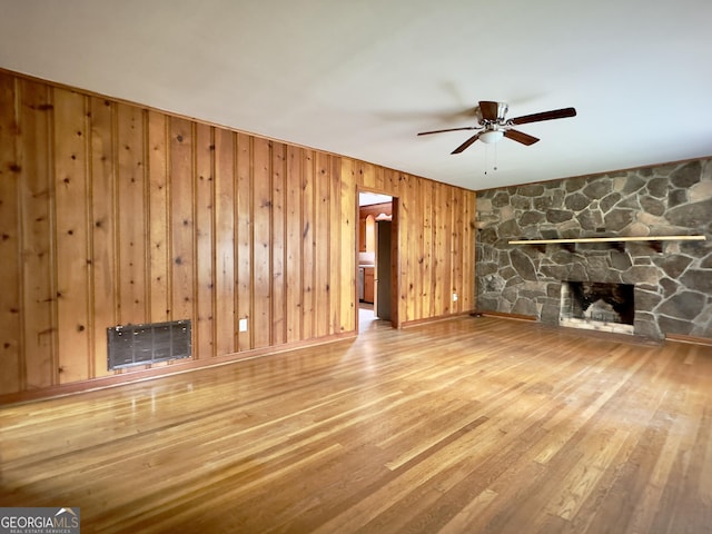 4 Walton Way NW, Rome, GA 30165 - unfurnished living room featuring ceiling fan, wood finished floors, wooden walls, and a fireplace