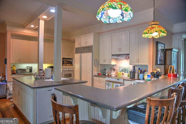 12001 Layfield Rd, Upatoi, GA 31829 - kitchen featuring white oven, stainless steel microwave, under cabinet range hood, crown molding, and recessed lighting