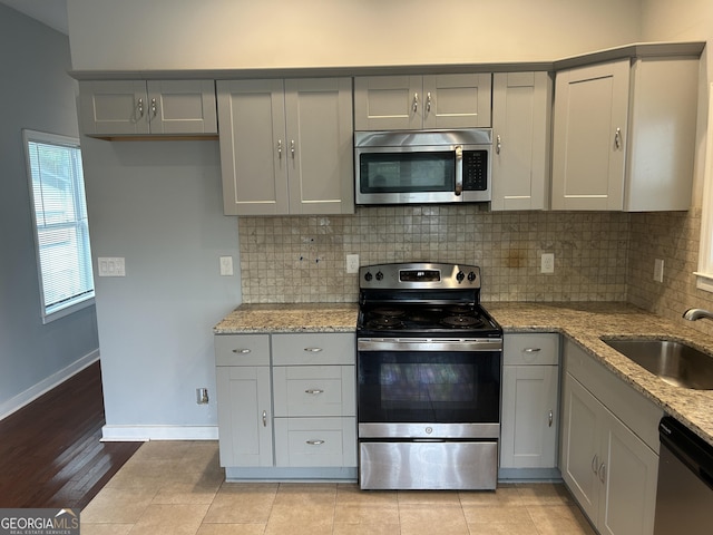 490 Rockwell St SW, Atlanta, GA 30310 - kitchen featuring stainless steel appliances, gray cabinets, backsplash, and light stone counters