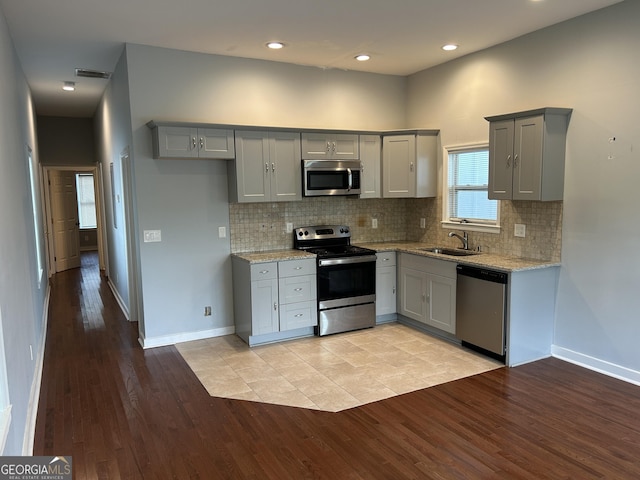 490 Rockwell St SW, Atlanta, GA 30310 - kitchen featuring appliances with stainless steel finishes, gray cabinets, light wood-style floors, light stone counters, and recessed lighting