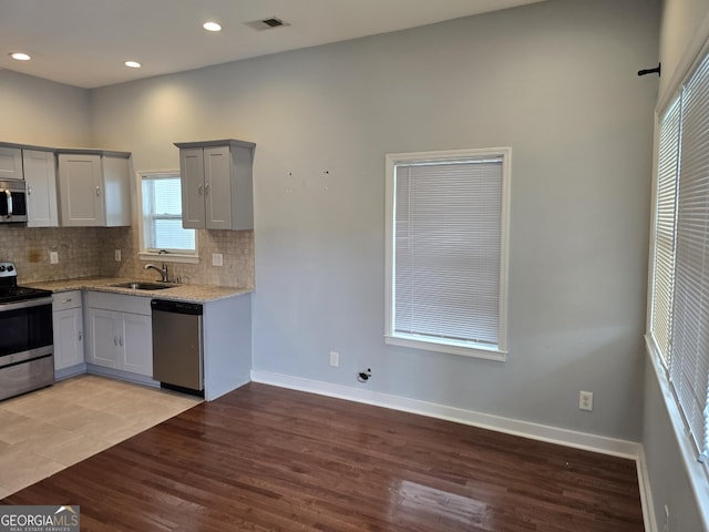490 Rockwell St SW, Atlanta, GA 30310 - kitchen featuring appliances with stainless steel finishes, gray cabinets, backsplash, light stone countertops, and recessed lighting