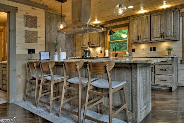 190 Toccoa Heights Rd, Blue Ridge, GA 30513 - kitchen with island range hood, dark wood-type flooring, brown cabinets, wooden walls, and a kitchen breakfast bar