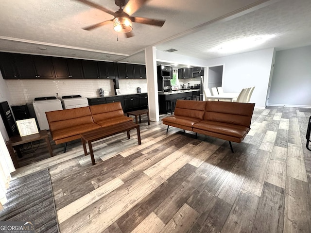 2220 Youth Monroe Rd, Monroe, GA 30655 - sitting room with washing machine and clothes dryer, a ceiling fan, light wood-style floors, a textured ceiling, and baseboards