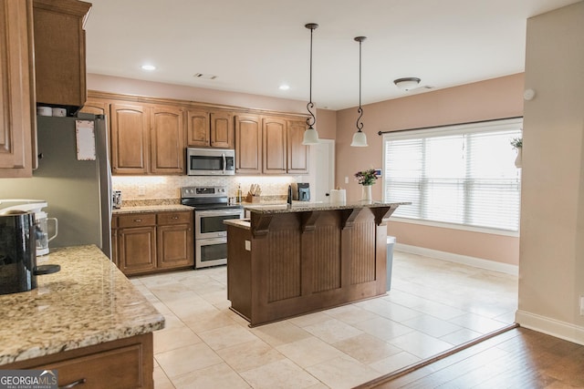 1325 Adams Rd, Meansville, GA 30256 - kitchen featuring stainless steel appliances, baseboards, decorative backsplash, a breakfast bar area, and light stone counters