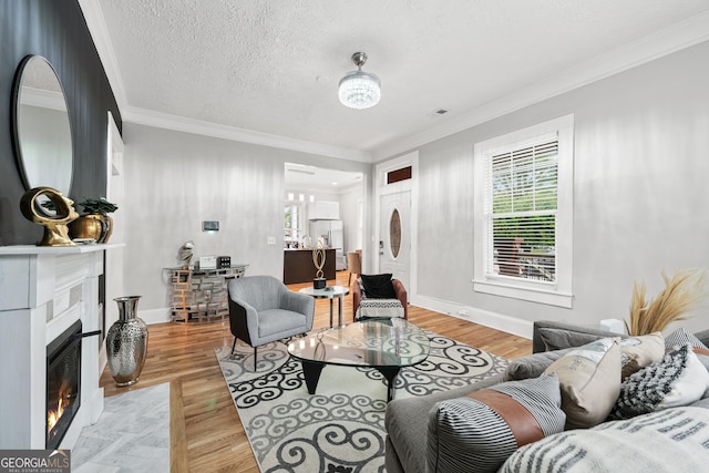 50 Ormond St SW, Atlanta, GA 30315 - living room featuring crown molding, plenty of natural light, a fireplace with flush hearth, light wood-type flooring, and baseboards