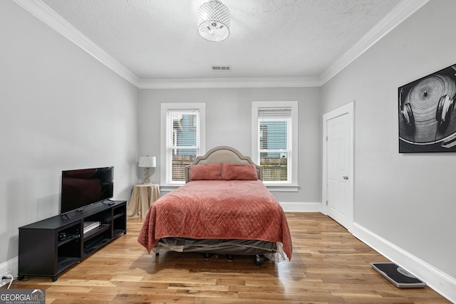 50 Ormond St SW, Atlanta, GA 30315 - bedroom featuring a textured ceiling, ornamental molding, light wood-style flooring, and baseboards