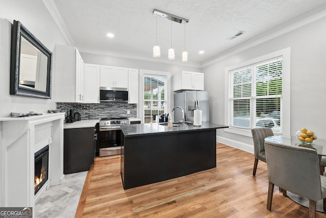 50 Ormond St SW, Atlanta, GA 30315 - kitchen featuring stainless steel appliances, a sink, crown molding, hanging light fixtures, and backsplash