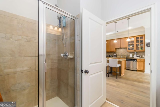 11 Perimeter Ctr E Unit 1412, Atlanta, GA 30346 - bathroom featuring a shower stall, wood finished floors, vanity, and tasteful backsplash