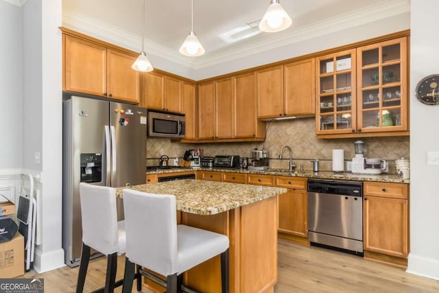 11 Perimeter Ctr E Unit 1412, Atlanta, GA 30346 - kitchen featuring appliances with stainless steel finishes, crown molding, light stone counters, hanging light fixtures, and a kitchen breakfast bar