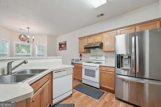 2545 Gatewater Ct, Cumming, GA 30040 - kitchen with white appliances, a sink, under cabinet range hood, light wood-style flooring, and a chandelier