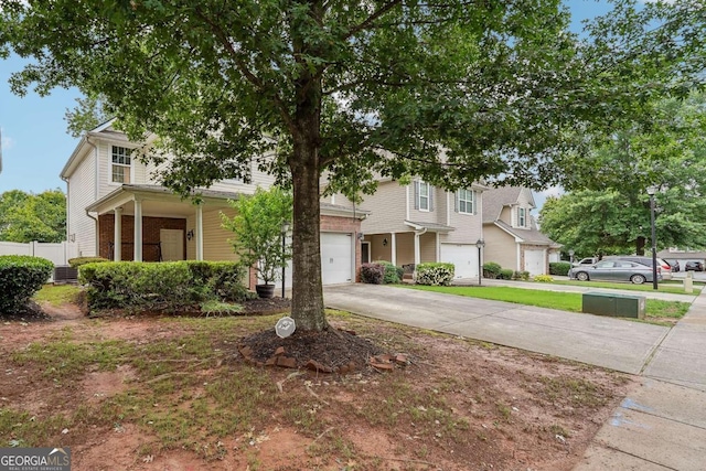 2545 Gatewater Ct, Cumming, GA 30040 - view of property hidden behind natural elements featuring a garage, concrete driveway, a porch, and brick siding