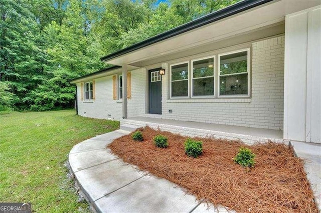 327 Marty Ln, Dallas, GA 30132 - doorway to property featuring brick siding, a yard, and covered porch