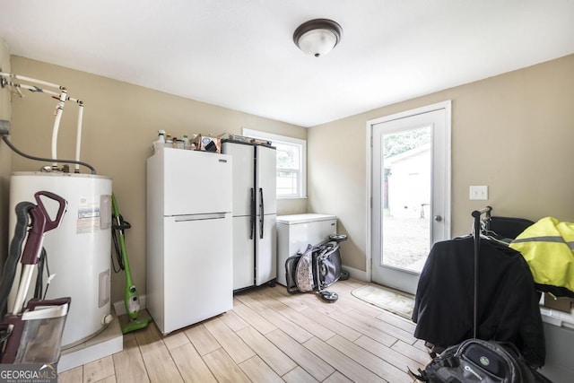 213 Feagin Mill Rd, Warner Robins, GA 31088 - kitchen featuring freestanding refrigerator, water heater, light wood-style flooring, and baseboards