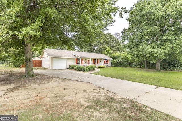 213 Feagin Mill Rd, Warner Robins, GA 31088 - ranch-style house featuring concrete driveway, a garage, a porch, a front yard, and view of wooded area