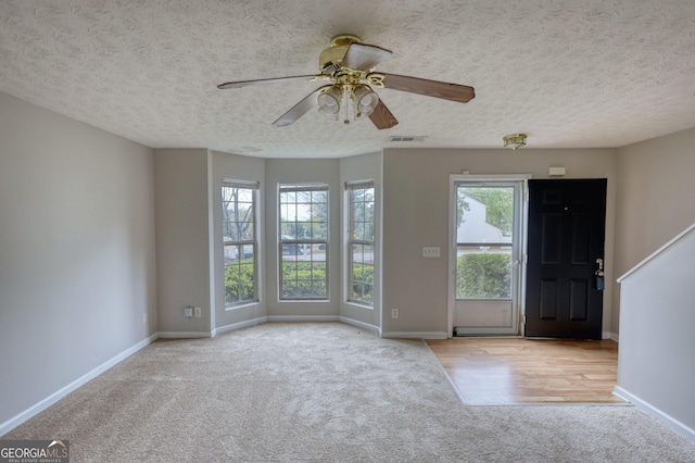 5587 Strathmoor Manor Cir, Lithonia, GA 30058 - foyer with carpet floors, ceiling fan, baseboards, and a textured ceiling