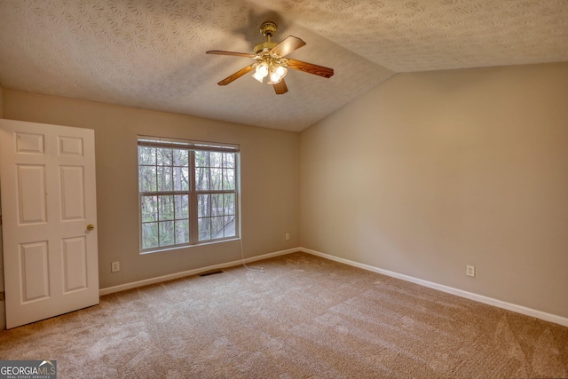 5587 Strathmoor Manor Cir, Lithonia, GA 30058 - spare room featuring ceiling fan, baseboards, carpet floors, a textured ceiling, and vaulted ceiling