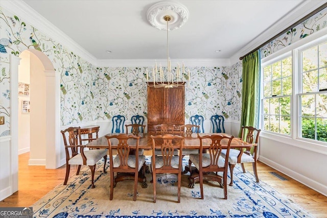 116 Maimont Cir, Macon, GA 31210 - dining space with wallpapered walls, ornamental molding, arched walkways, and wood finished floors