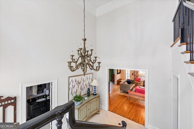 116 Maimont Cir, Macon, GA 31210 - hallway with a high ceiling, a chandelier, light tile patterned flooring, stairs, and ornamental molding