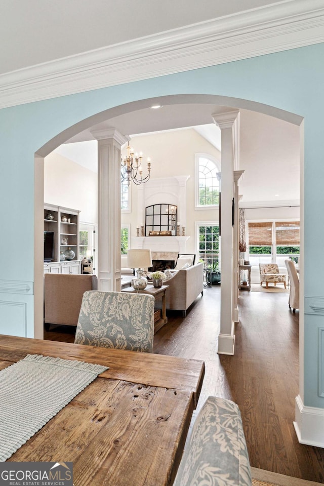 100 Pine Mist Cir, Alpharetta, GA 30022 - dining space featuring crown molding, arched walkways, decorative columns, dark wood finished floors, and a fireplace