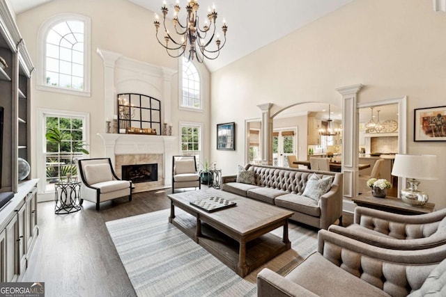 100 Pine Mist Cir, Alpharetta, GA 30022 - living room with high vaulted ceiling, a chandelier, a high end fireplace, wood finished floors, and arched walkways