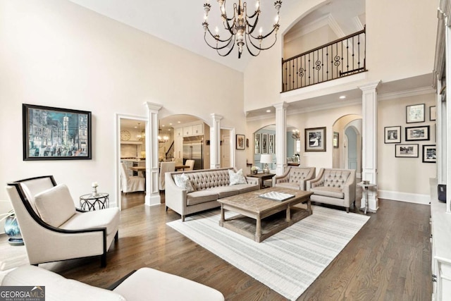 100 Pine Mist Cir, Alpharetta, GA 30022 - living area with decorative columns, arched walkways, a chandelier, wood finished floors, and a towering ceiling