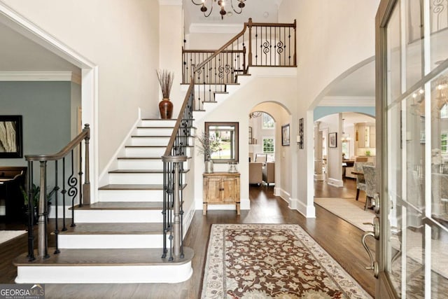 100 Pine Mist Cir, Alpharetta, GA 30022 - foyer entrance featuring arched walkways, wood finished floors, crown molding, stairs, and a towering ceiling