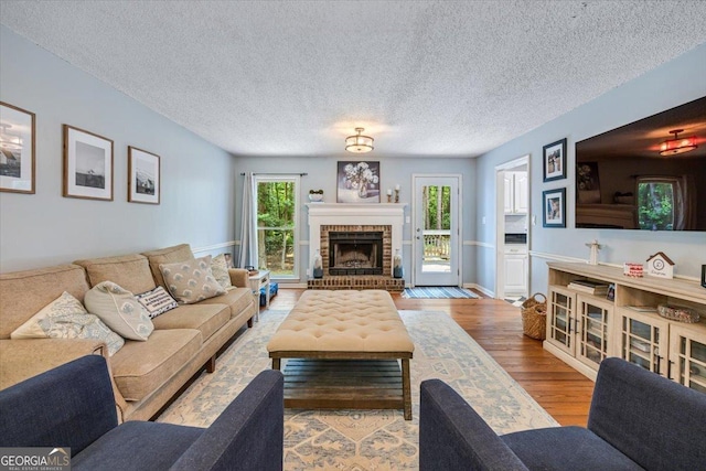 6121 Peake Rd, Macon, GA 31220 - living area with wood finished floors, a fireplace, and a textured ceiling