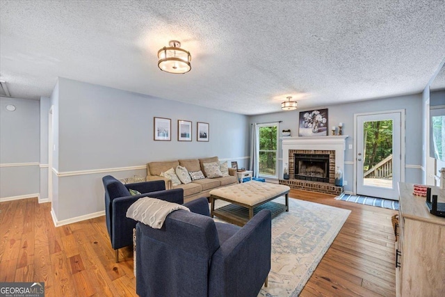 6121 Peake Rd, Macon, GA 31220 - living area with a textured ceiling, wood finished floors, a fireplace, and baseboards