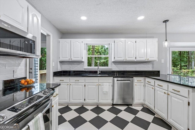 6121 Peake Rd, Macon, GA 31220 - kitchen with stainless steel appliances, a sink, white cabinets, decorative backsplash, and light flooring