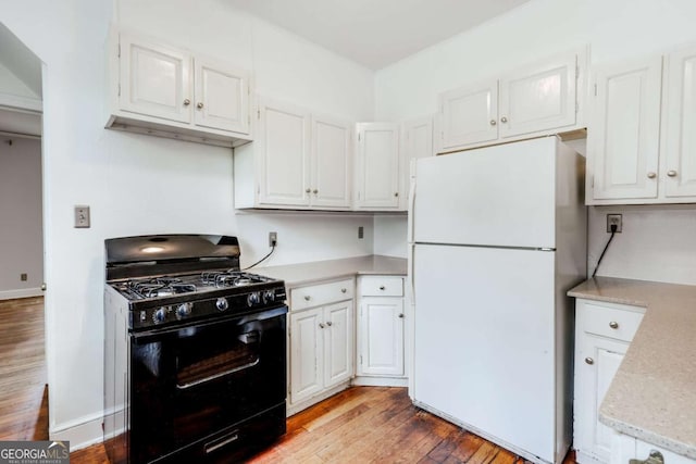 170 Stanton Way, Athens, GA 30606 - kitchen with freestanding refrigerator, black gas stove, light wood-style flooring, and white cabinetry