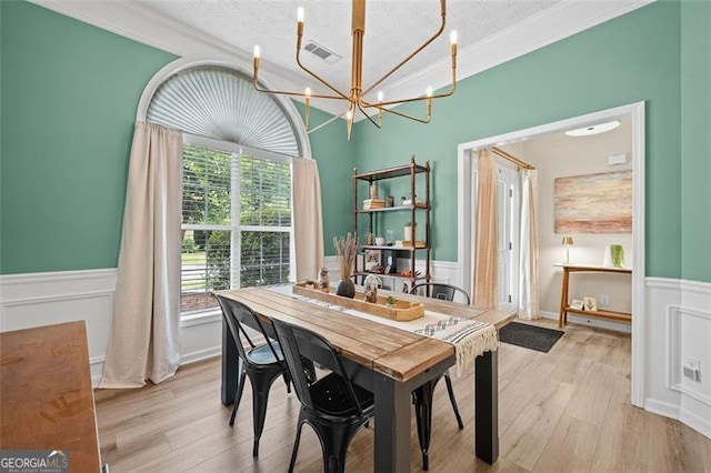 1865 Morgans Run Trl, Buford, GA 30519 - dining room with wainscoting, a chandelier, wood finished floors, ornamental molding, and a textured ceiling