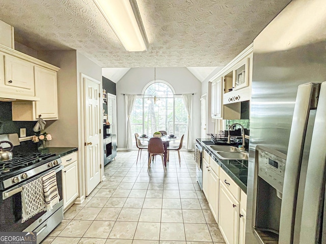 329 Royal Crescent Way, Stockbridge, GA 30281 - kitchen featuring appliances with stainless steel finishes, under cabinet range hood, dark countertops, a sink, and vaulted ceiling