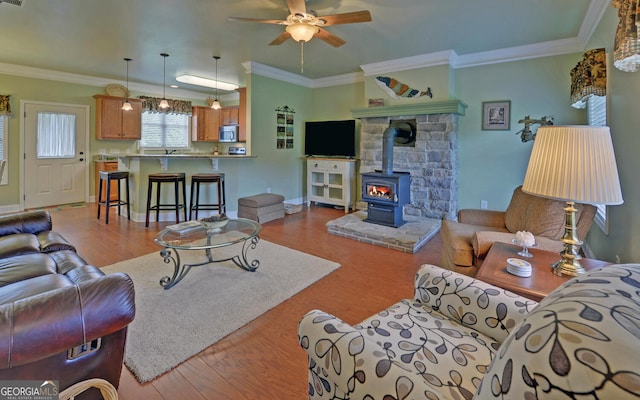 60 Villa Cts, Hartwell, GA 30643 - living area featuring a wood stove, wood finished floors, ceiling fan, crown molding, and baseboards