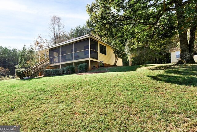 557 Hidden Pines Ct, Hiawassee, GA 30546 - back of property featuring a sunroom, a lawn, and stairway