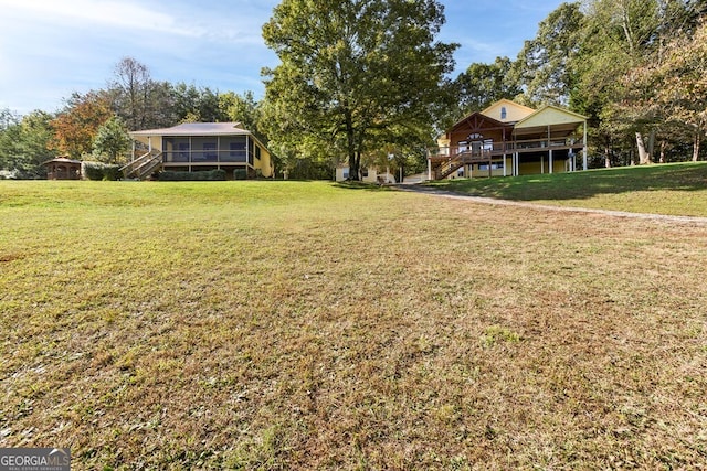 557 Hidden Pines Ct, Hiawassee, GA 30546 - view of green lawn with stairway, a sunroom, and a deck