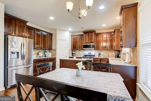 3746 Okefenokee Rdg, Loganville, GA 30052 - kitchen featuring stainless steel appliances, backsplash, hanging light fixtures, a chandelier, and recessed lighting