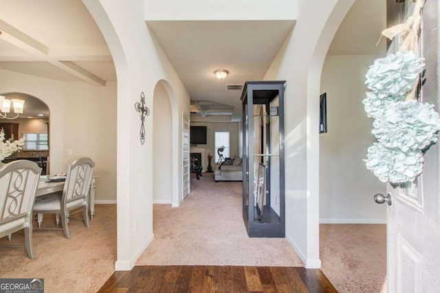 3746 Okefenokee Rdg, Loganville, GA 30052 - carpeted entrance foyer featuring wood finished floors, arched walkways, and beam ceiling
