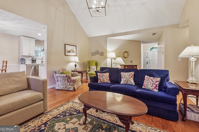 412 Rock Creek Dr, Peachtree City, GA 30269 - living room featuring light wood finished floors, high vaulted ceiling, and a chandelier